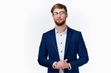 Mavi ceketli ve gözlüklü hafif gömlekli bir adam elleriyle hareket ediyor. 