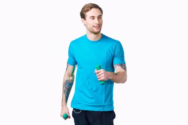 Elinde dambıl tutan yakışıklı sporcu fitness hafif arka plan