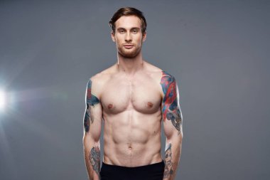 Sportif adam gaza geldi. Basın, kollarıyla hareket ediyor. Gri arka plan.