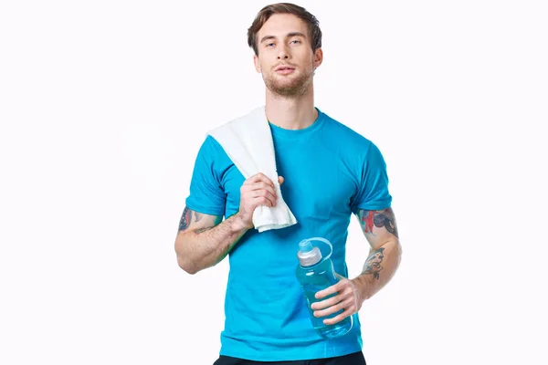 Homem bonito com uma garrafa de água em suas mãos esporte fitness tatuagem — Fotografia de Stock
