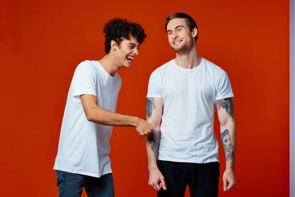 Два друга в белых футболках стоят бок о бок изолированный фон — стоковое фото