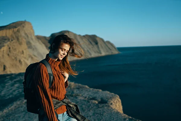 Frau reist in den Bergen mit Rucksack in der Nähe des Meeres — Stockfoto