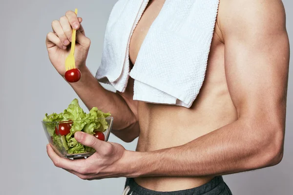 A man holding a plate of salad food ration towel on his shoulders inflated torso — Stock Photo, Image