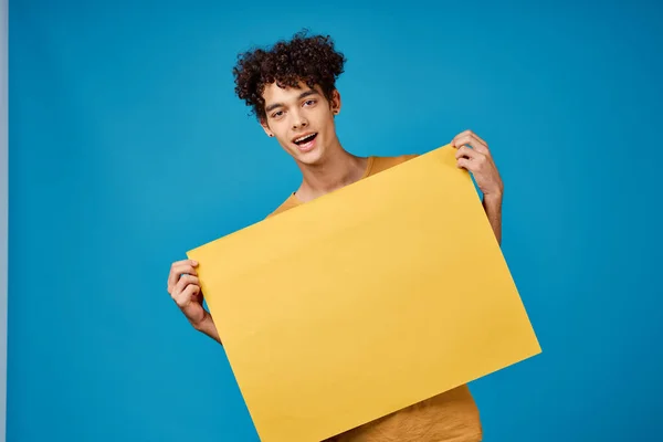 노란 날카로운 광고 카피 스페이스 블루 배경을 가진 웃기는 곱슬머리 남자 — 스톡 사진