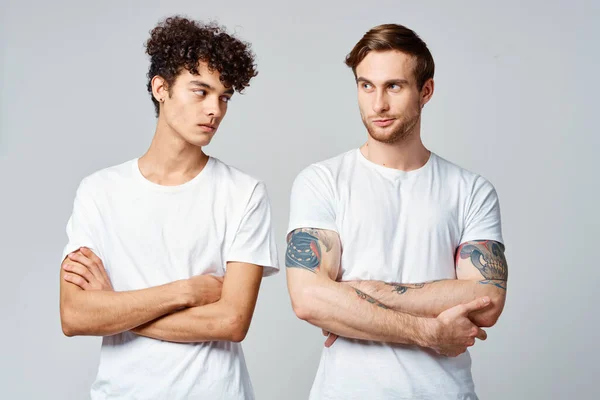 Dos hombres en camisetas blancas de pie lado a lado recortado ver estudio amistad — Foto de Stock