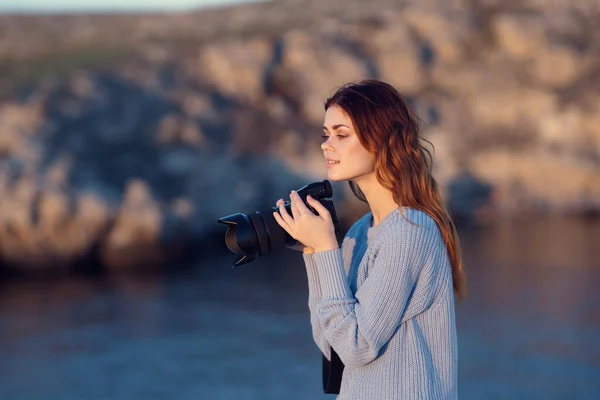 woman photographer in nature with camera in rocky mountains professional