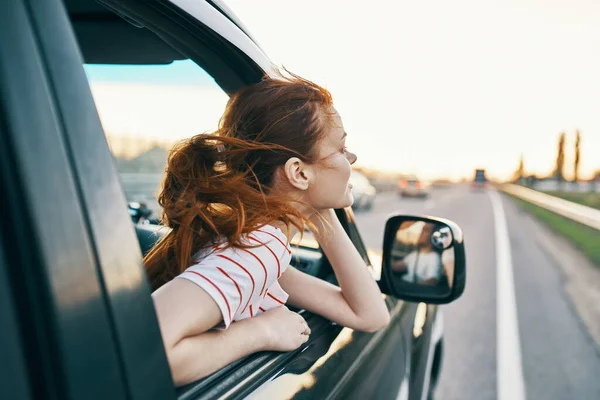 Mujer feliz en la pista asomándose por la ventana del coche en vacaciones de verano y turismo de viajes — Foto de Stock