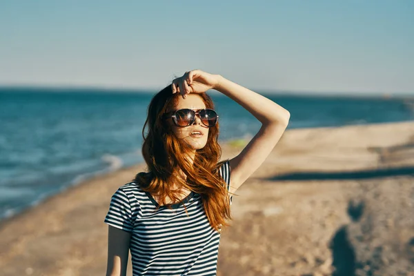 Kvinna promenader på stranden nära havet i bergen på sommaren i naturen — Stockfoto