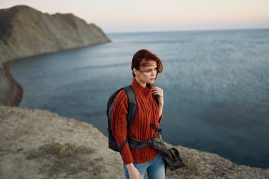 Doğada ve denizde dağların yanında gezgin. Uzakta, sırt çantalı, sırt çantalı.