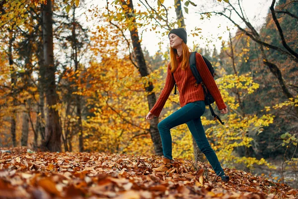 Beautiful woman with a backpack in the park on nature landscape fallen leaves bottom view — Stock Photo, Image