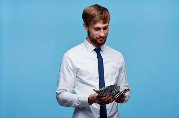 Hombre con fajo de dinero finanzas fondo azul oficial —  Fotos de Stock