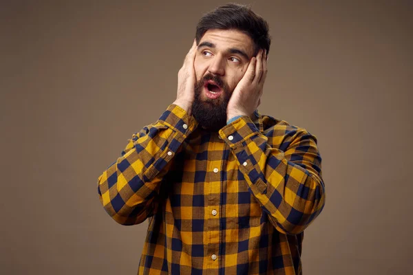 Homme barbu en chemise à carreaux tenant à faire face aux émotions — Photo