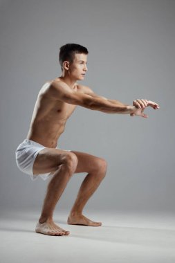 Adam gri arka planda spor yapıyor.