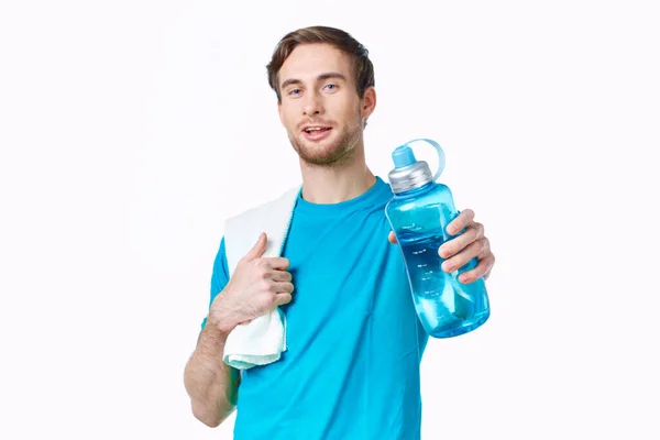 Sportovní muž v modrém tričku voda láhev ručníky cvičení — Stock fotografie