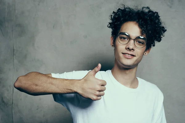 Divertente ragazzo dai capelli ricci gesticolando con la mano indossando occhiali emozioni vista ritagliata — Foto Stock