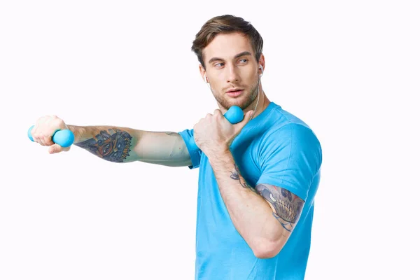 Uomo sportivo in t-shirt blu con manubri fitness esercizio vista ritagliata — Foto Stock
