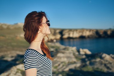 Kadınlar nehre yakın eserler, geriye bakarlar ve mavi gökyüzü manzarası