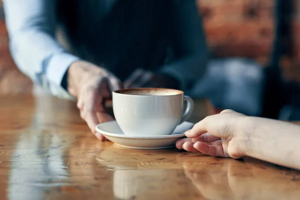 Camarero feliz sirviendo una taza de café a un paciente en un café beber ladrillo interior de la pared — Foto de Stock