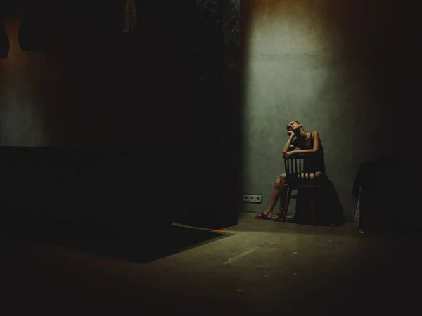 Femme assise sur des chaises dans la chambre noire solitude conflit dépression modèle intérieur — Photo