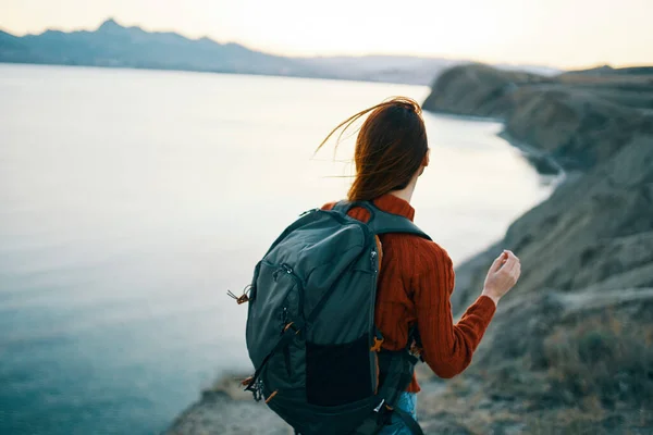 Un viaggiatore con uno zaino sulla schiena guarda il mare in lontane montagne paesaggio oceano acqua limpida — Foto Stock