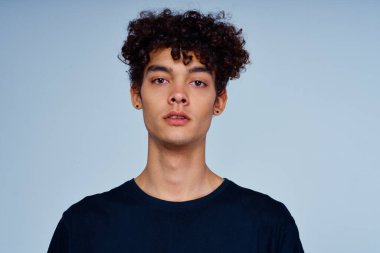 Siyah tişörtlü kıvırcık saçlı adam izole edilmiş arka plan.