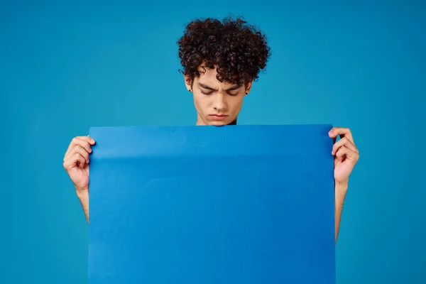 Chico sosteniendo banner azul anuncio copia espacio aislado fondo —  Fotos de Stock