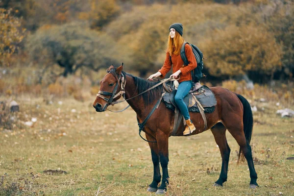 Woman hiker in the mountains riding a horse travel lifestyle — Stock Photo, Image