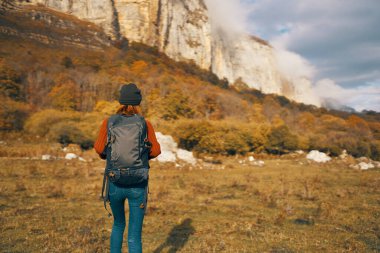 Sırt çantalı kadın doğada gezer ve dağlara tırmanır.