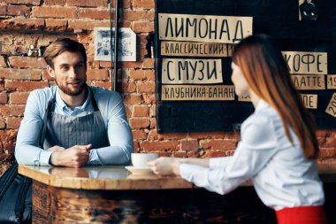 Kafe tuğlalı duvar müşterilerinin menüsünde bir şef. İç oda içeceği bardağı.