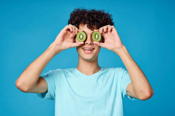 Hombre con el pelo rizado kiwi cerca de la cara fondo azul vista recortada — Foto de Stock