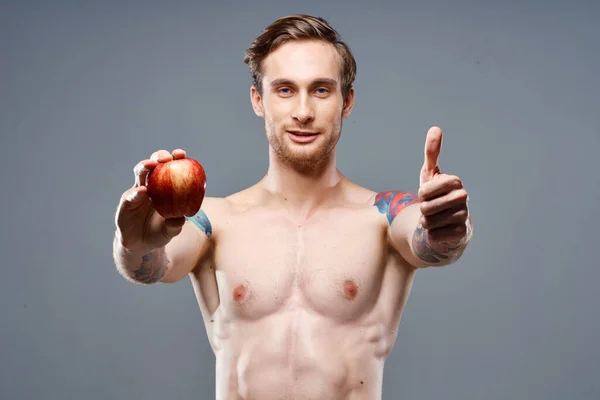 Atlético chico con un torso bombeado estilo de vida saludable nutrición vitaminas manzana roja — Foto de Stock