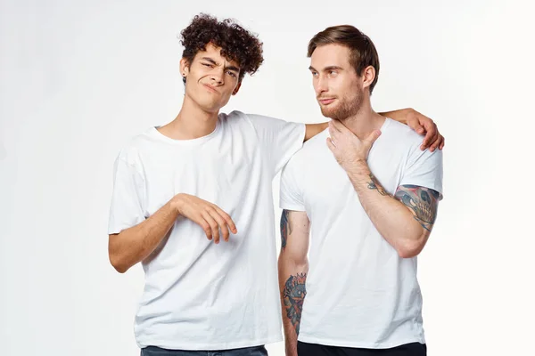 하얀 티셔츠를 입은 두 명의 쾌활 한 친구가 감정을 받아들인다 — 스톡 사진