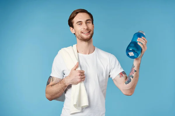 Χαρούμενος αθλητικός άνθρωπος σε λευκό t-shirt μπουκάλι νερό ενέργειας μπλε φόντο — Φωτογραφία Αρχείου