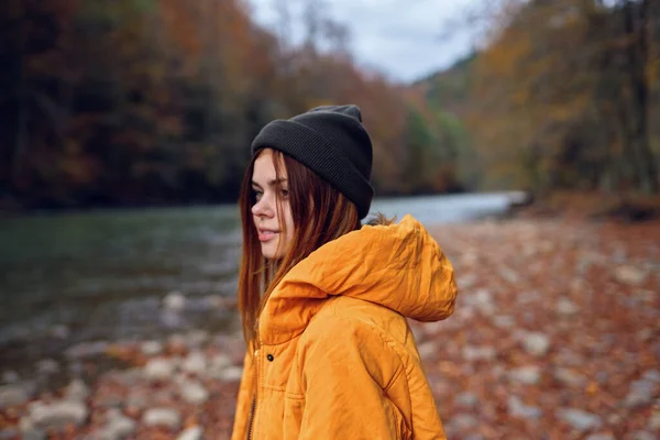 Mujer camina en el bosque de otoño en una chaqueta amarilla montañas viaje —  Fotos de Stock