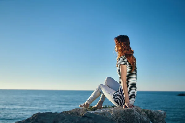 Woman hiker on a rock near the sea sunset blue sky and transparent water model — Stock Photo, Image