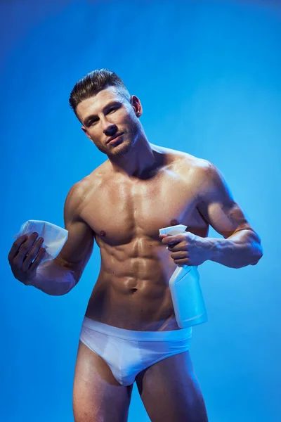 Uomo con pompato fino abs in mutandine bianche detergente sfondo blu — Foto Stock