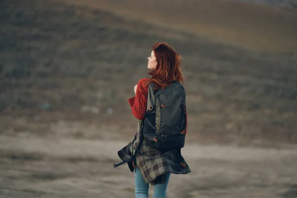 Žena v horách s batohem na ramenou zpět pohled cestovní turistika rock — Stock fotografie
