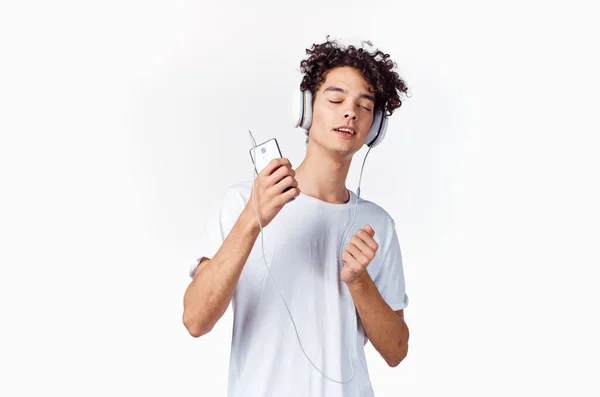 Chico emocional con el pelo rizado en los auriculares escuchando música divertida — Foto de Stock