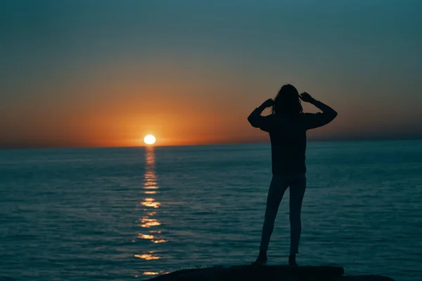 Woman gesturing with her hands and sunset sea landscape beach — Stock Photo, Image