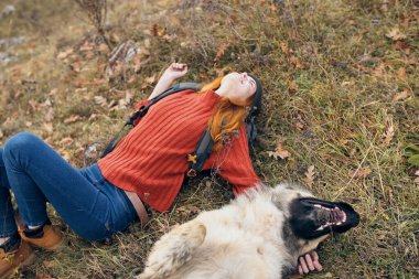 Otostopçu kadın köpek dostluğu oyunlarının yanında yatıyor.
