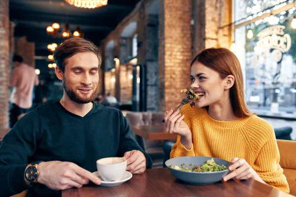 여자와 남자 가 식당에서 샐러드 식사를 하며 커피 한잔을 하는 모습 — 스톡 사진