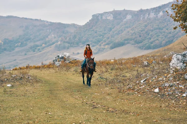 Žena turistka v horách na koni dobrodružství životní styl — Stock fotografie
