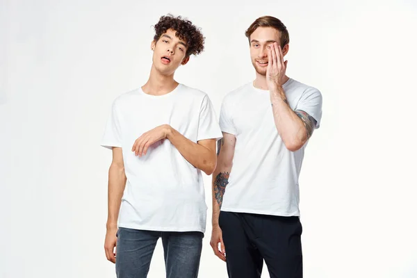 하얀 티셔츠를 입고 긍정적 인 감정을 가진 두 명의 유쾌 한 친구 — 스톡 사진