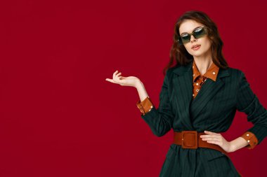 Güneş gözlüklü güzel bir kadın. El yapımı arka plan stüdyosu var.