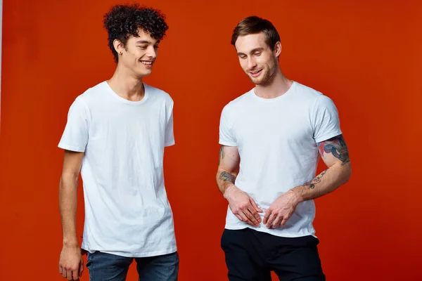 Due amici t-shirt stand fianco a fianco su sfondo isolato studio — Foto Stock