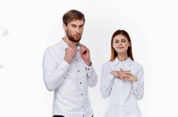 シャツに身を包んだビジネスマンと軽い背景を持つ女性従業員がパートナーの手でジェスチャーをしています — ストック写真