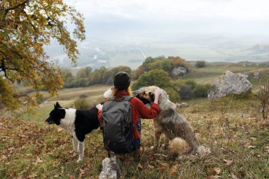 Sırt çantalı bir kadın doğa yürüyüşçüsü köpek gezintisine çıkıyor.