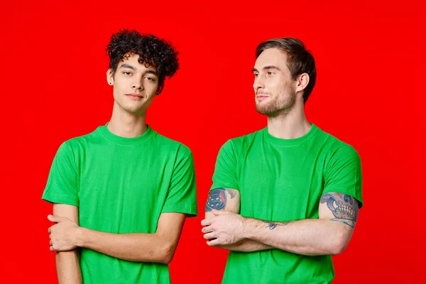 Yeşil tişörtlü iki adam yan yana duruyor. — Stok fotoğraf