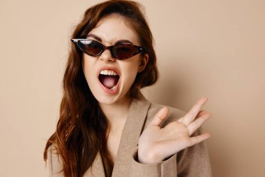 Ağzında güneş gözlüğü olan enerjik bir kadın. Yüksek kalite fotoğraf