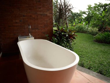 Veranda odasındaki beyaz banyo arka planda doğa manzarası olan birliktelik tasarımı.